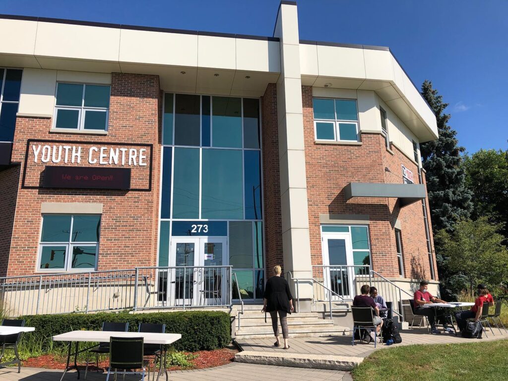 The Youth Unlimited Youth Centre in Waterdown, with young people gathered at tables outside the entrance